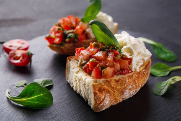 istock Bruschetta with cheese and vegetables on black background 840473262