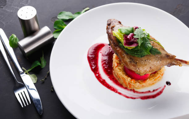 istock Restaurant meals. Duck confit with vegetables on black background 840473422