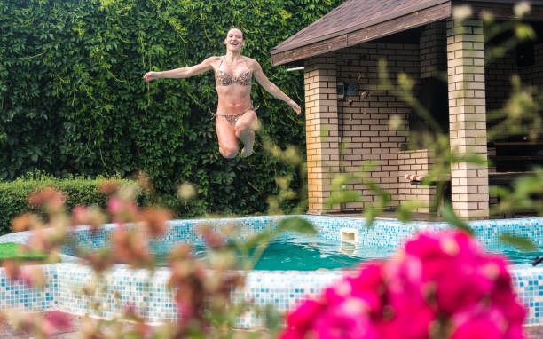 istock Pool. Girl jumping into the pool 840481982