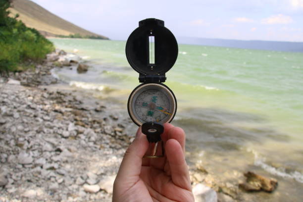 istock Compass in the hand on the nature background. 840482472