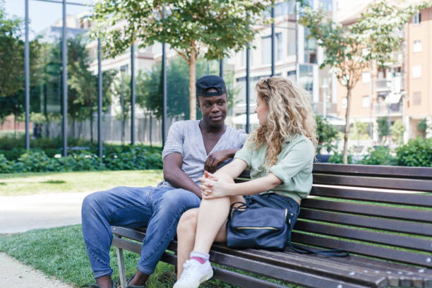istock Loving couple talking on bench in a park during summer 840488490