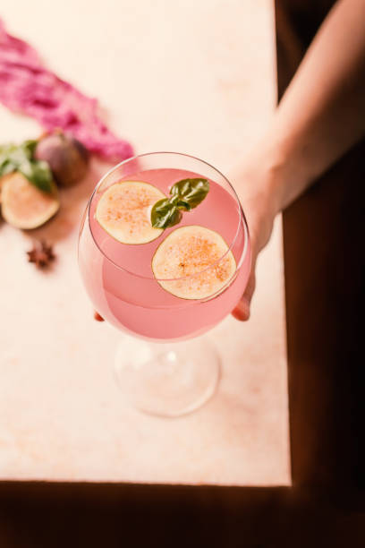 Pink cocktail with fig Pink cocktail with fig and basil on light background close up polypodiaceae stock pictures, royalty-free photos & images