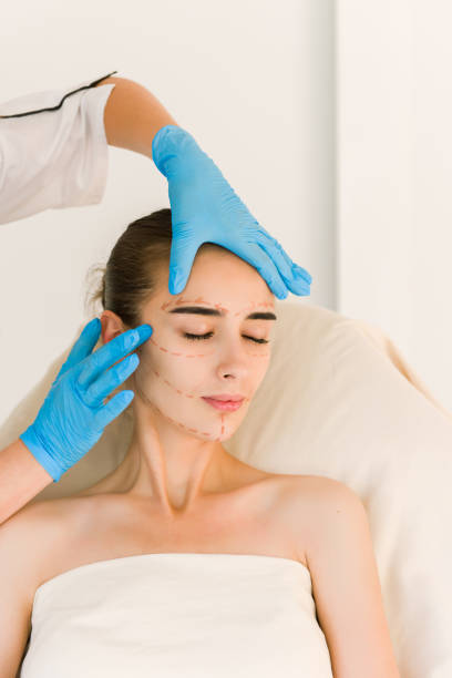 istock Cosmetic surgeon examining female client in office 840489126