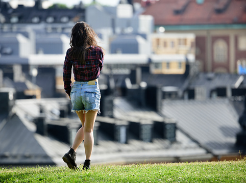 Woman using phone, Stockholm rooftops in background