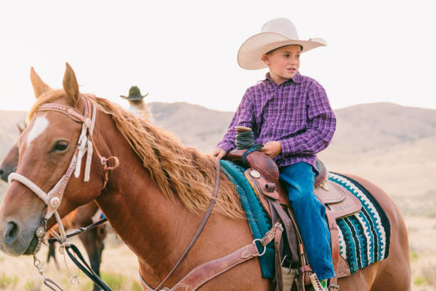 istock Young cowboy sitting on his horse 840496510