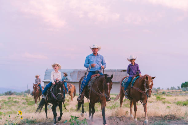 kowboj ojciec i synowie o zachodzie słońca - cowboy cowboy hat hat summer zdjęcia i obrazy z banku zdjęć