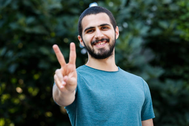 istock Handsome man with beaming smile showing two fingers 840497392