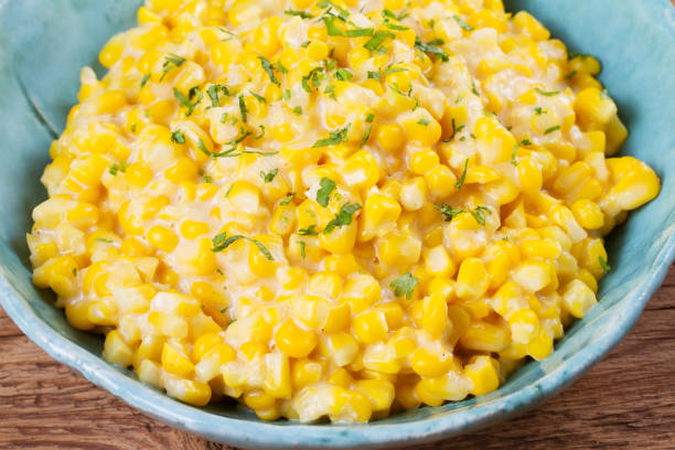 Creamy corn in bowl on wooden background