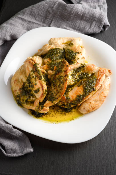 tasty roasted chicken breast with pesto sauce. dark still life - chicken breast chicken grilled chicken protein imagens e fotografias de stock