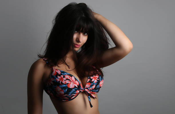 Beautiful young woman leaning on a white box with her hand on her cheek.
