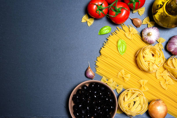 istock Top view: pasta or italian spaghetti on black stone slate background 840506496