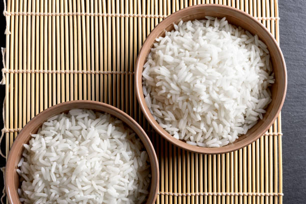 istock Top view: steamed cooked white basmati rice in round ceramic bowls over black stone 840509370