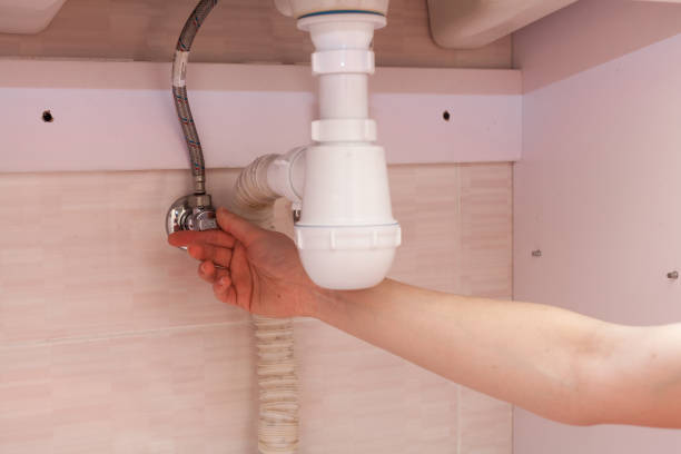 Exposed plastic plumbing attached to a copper joint with a shut-off valve under a white sink. Shut off the water supply to the sink in the bathroom.