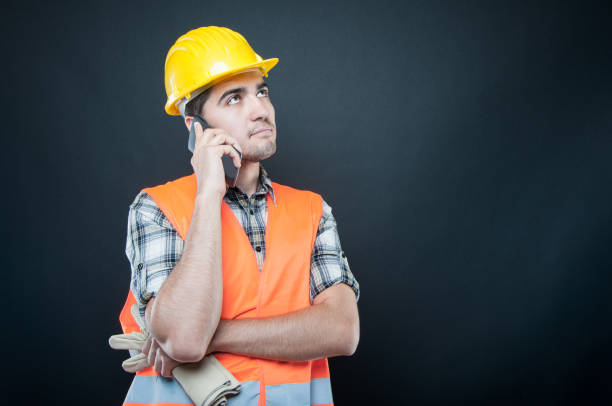 istock Constructor wearing equipment talking on phone holding gloves 840513362