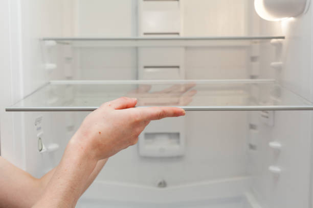 istock Installing new, clean shelves in an empty washed refrigerator. Young woman cleaning refrigerator 840514744