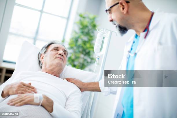 Doctor Talking To Patient In Hospital Bed Stock Photo - Download Image Now - Patient, Cancer - Illness, Bed - Furniture