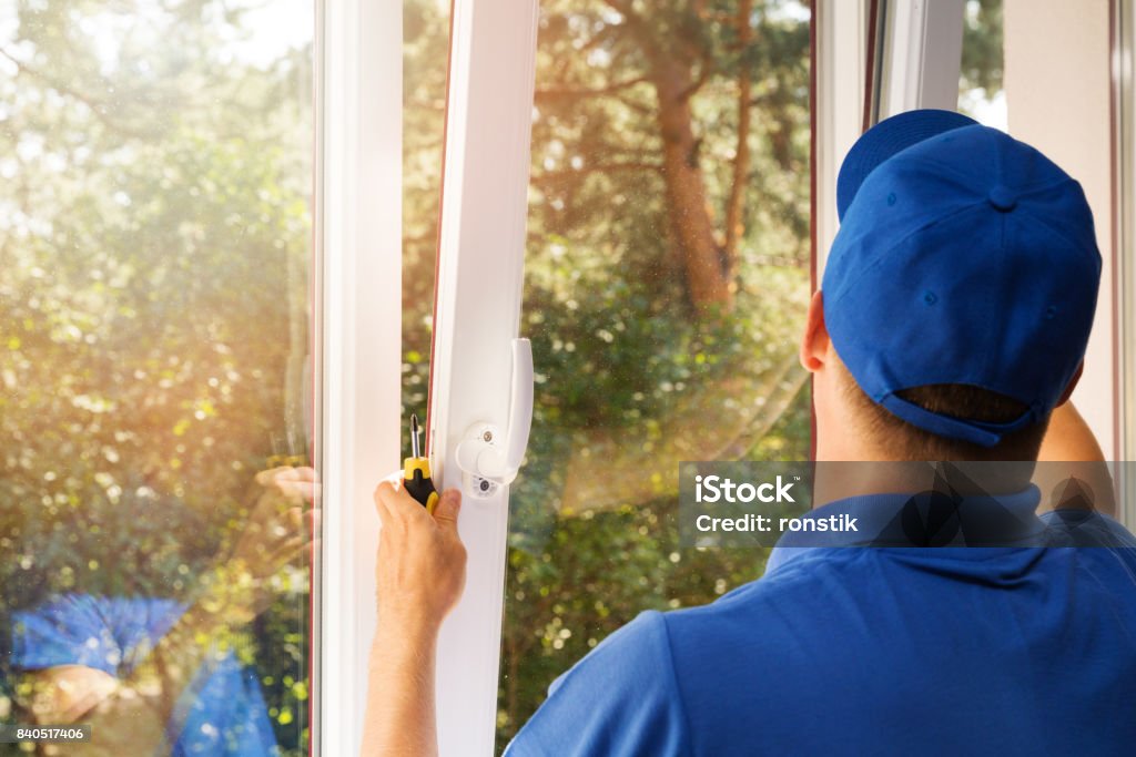 worker installing new plastic pvc window Window Stock Photo