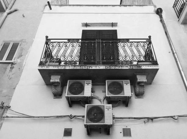 tres grandes aparatos de aire acondicionado fuera de un apartamento en italia - retrofitting fotografías e imágenes de stock