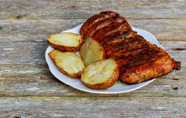 bistecca di striploin alla griglia con patate arrosto sul piatto sul tavolo di legno. - steak strip steak prepared potato grilled foto e immagini stock