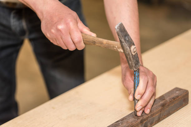 istock Male hands of builder man holding hammer and scored 840518982