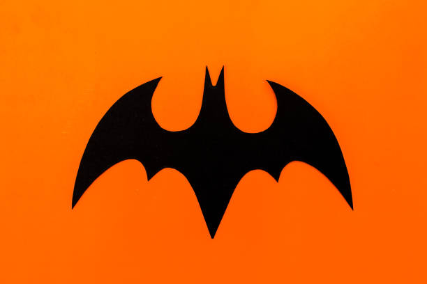 istock Halloween concept. Handmade black paper bat on orange background. Flat lay, top view. 840519030
