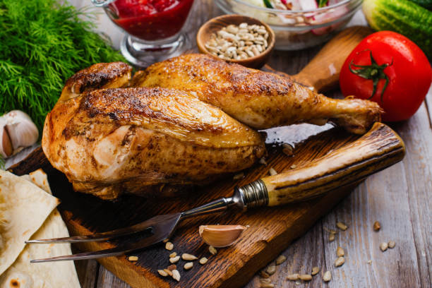 Roasted half chicken Roasted chicken with pita bread, tomato sauce and fresh raw vegetables on wooden table half full stock pictures, royalty-free photos & images
