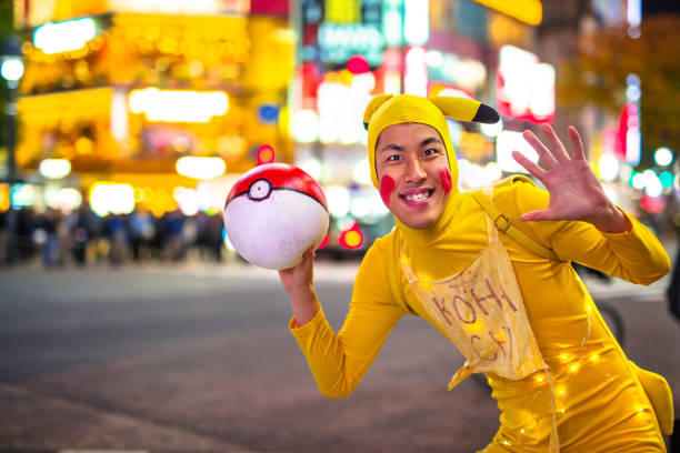 Man dressed up like Pikachu at Shibuya crosswalk in Tokyo TOKYO, JAPAN - NOVEMBER 12, 2016: Man dressed up like Pikachu at Shibuya crosswalk in Tokyo, Japan. Pikachu is a central character in the Pokémon anime series, famous in Japan. walking animation stock pictures, royalty-free photos & images