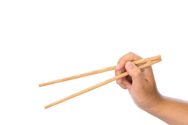 istock hand holding Wooden chopsticks isolated on white background 840535086
