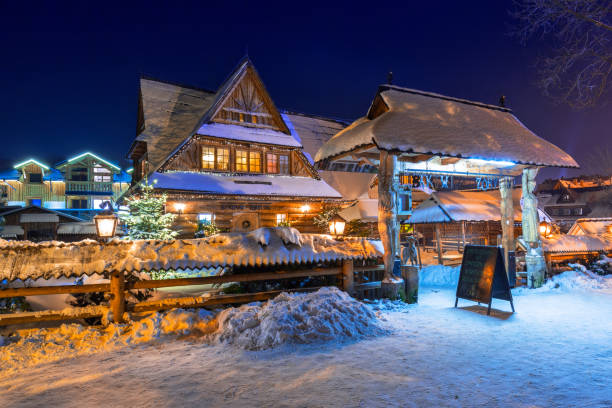 Wooden architecture of Zakopane at snowy night, Poland ZAKOPANE, POLAND - DECEMBER 30, 2016: Wooden architecture of Zakopane at snowy night, Poland. City center of Zakopane is the main shopping area with pedestrian promenade in Tatra mountains. zakopane stock pictures, royalty-free photos & images