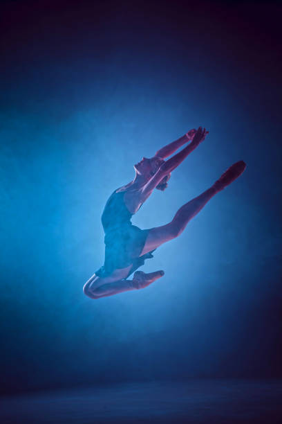 istock Beautiful young ballet dancer jumping on a lilac background 840536096