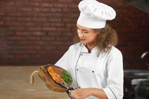 istock Professional chef cutting chicken steak with scissors 840540128