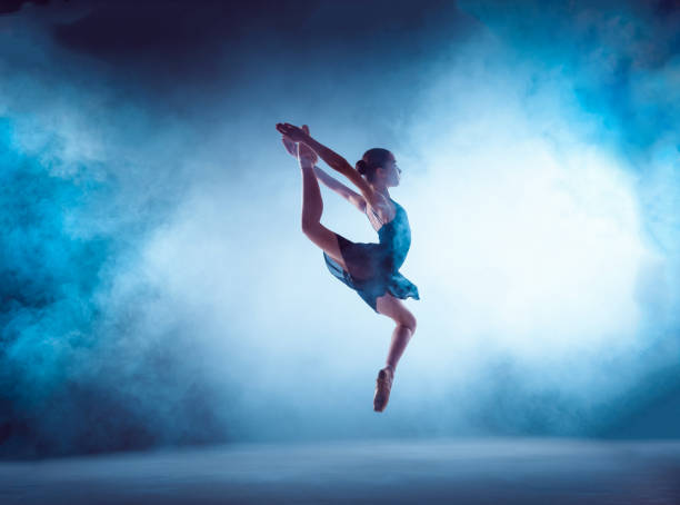 istock Beautiful young ballet dancer jumping on a lilac background 840543036