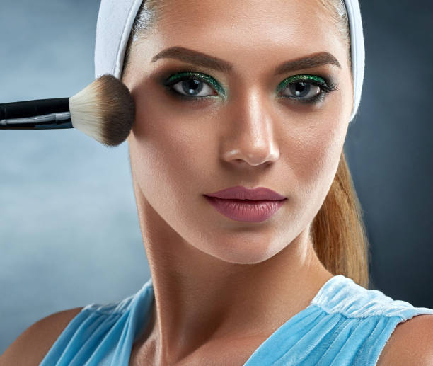 istock Sensual woman drawing blush for herself, making professional makeup. 840543548
