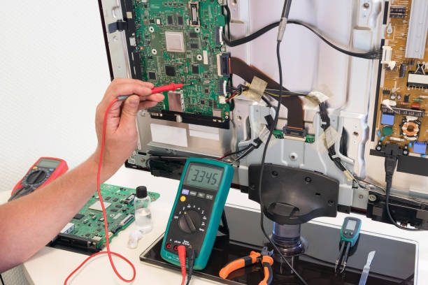 istock The consumer electronics repair engineer measures the voltage on the television board 840552604
