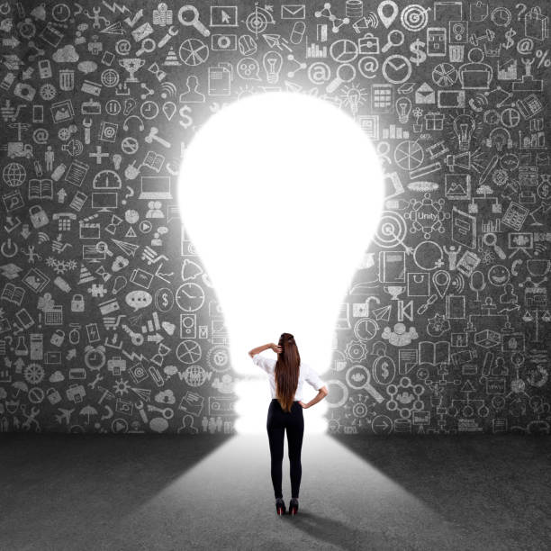 istock Confused businesswoman looking at light bulb 840552614