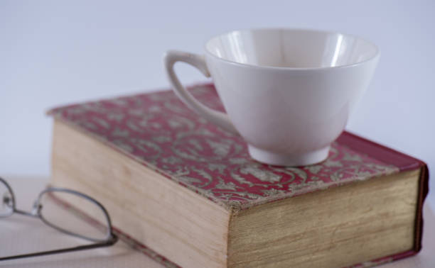 old hardbound book with spectacles and tea cup - hardbound imagens e fotografias de stock