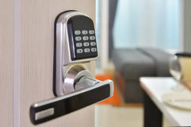 Photo of Electronic door access control system machine with number password door..Half opened door handle closeup, entrance to a living room.Door lock with keys number.