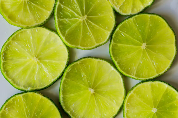 close-up de fatias de limão em um fundo branco, apropriado para textura e fundo. conceito de saúde. - lemon textured peel portion - fotografias e filmes do acervo