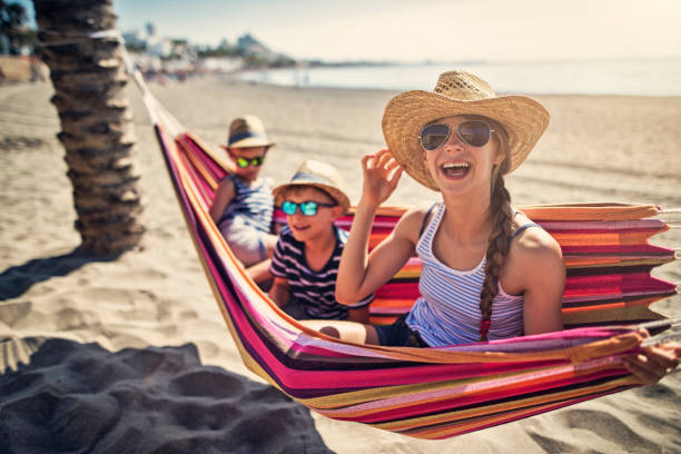 Kids having fun on hammock on beach Three kids resting on beach hammock. Sunny summer vacations day at beach and sea. Andalusia, Spain.
 málaga province photos stock pictures, royalty-free photos & images