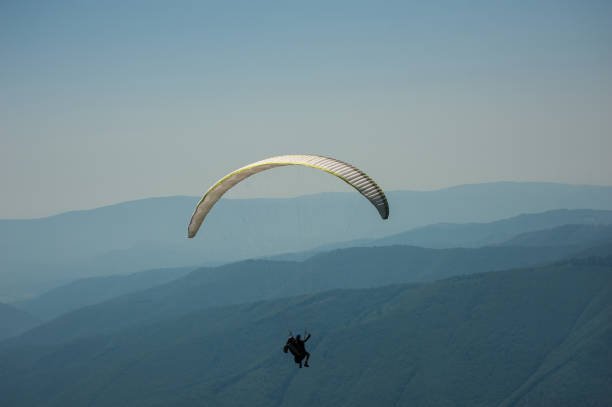 istock A paragliding tandem flies over a mountain valley on a sunny summer day. 840578538