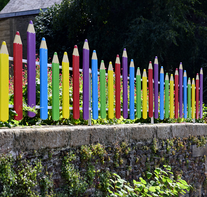 Wooden fence painted to look like pencils outside school. Seen outside many promary schools in Brittany, France.