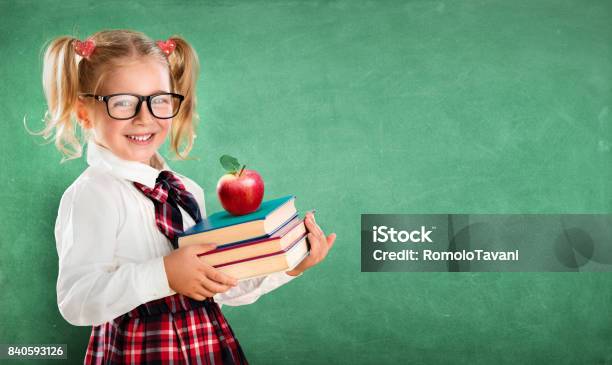 Colegiala Pequeña Con Libros Y Apple Foto de stock y más banco de imágenes de Comienzo del año escolar - Comienzo del año escolar, Niño de escuela primaria, Sonreír