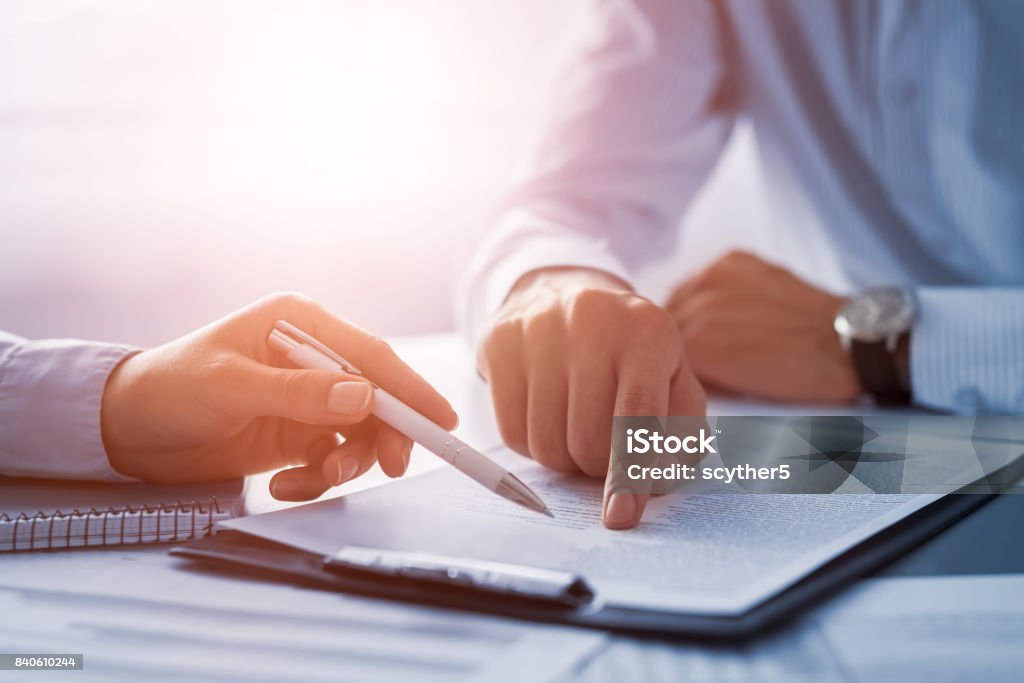 Business people negotiating a contract. Business people negotiating a contract. Human hands working with documents at desk and signing contract. Contract Stock Photo