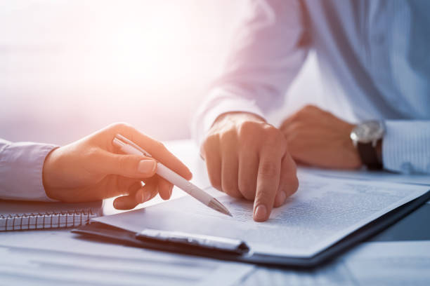 Business people negotiating a contract. Business people negotiating a contract. Human hands working with documents at desk and signing contract. insurance agent stock pictures, royalty-free photos & images