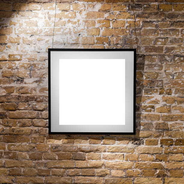istock Empty frame on light brick wall. Blank space poster or art frame waiting to be filled. Square Black Frame Mock-Up 840611778