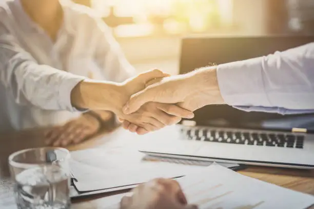 Photo of Business people shaking hands. Finishing up meeting.