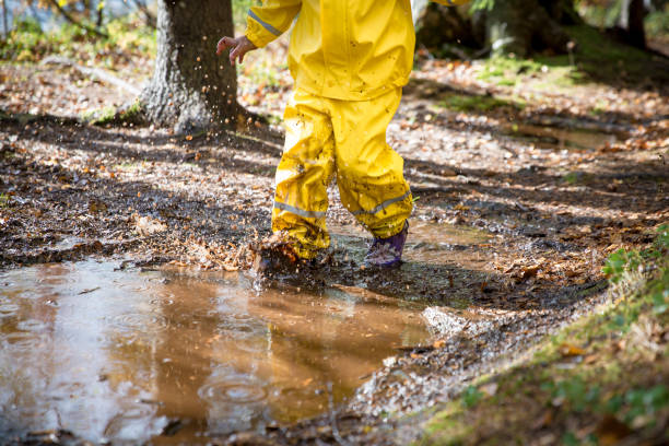 istock Cute little girl jumping in muddy puddle 840614676
