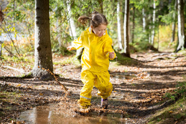 istock Cute little girl jumping in muddy puddle 840614780
