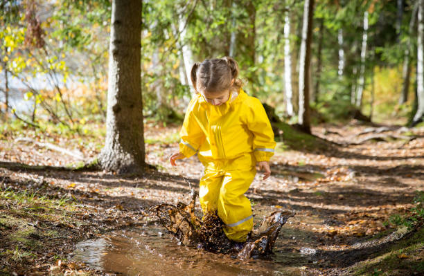istock Cute little girl jumping in muddy puddle 840614916