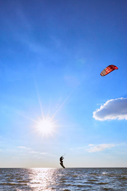 Happy child girl running with multicoloured flying kite at sunset